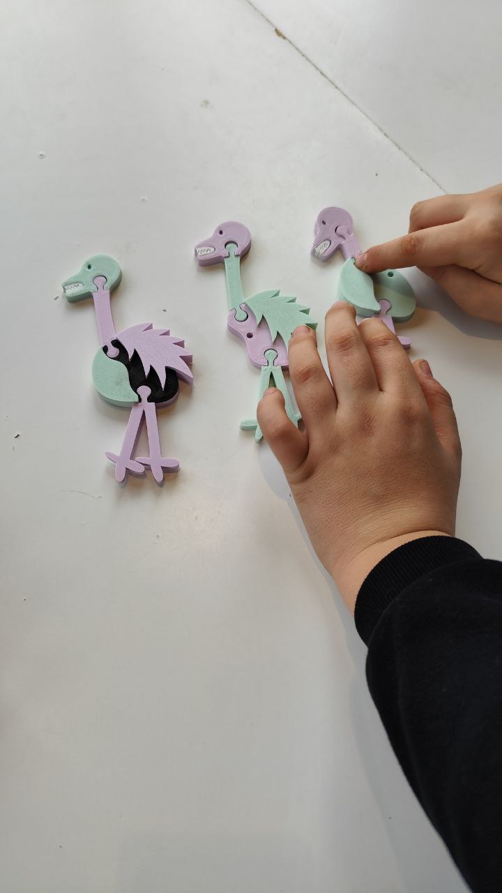 le mani di un bambino compongono i pezzi degli animali del gioco "l'evoluzione mi fa specie"